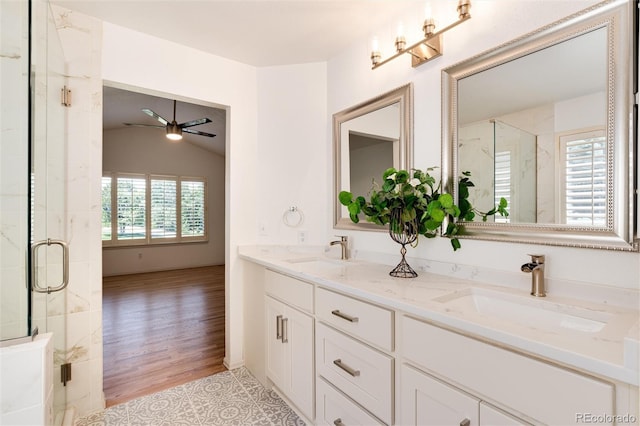 bathroom featuring ceiling fan, plenty of natural light, wood-type flooring, and vaulted ceiling