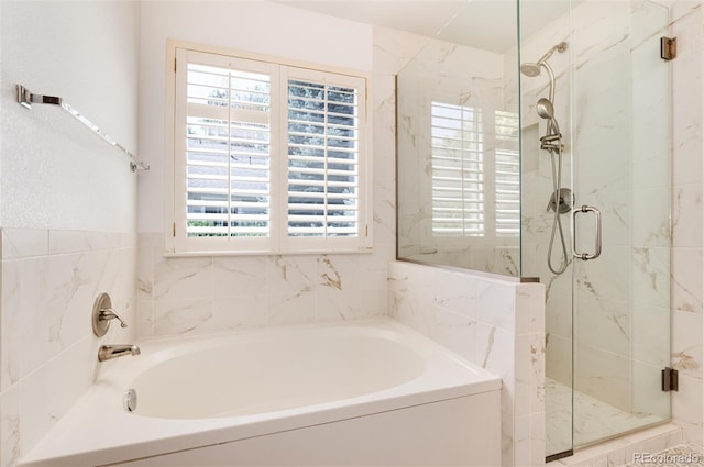 bathroom with shower with separate bathtub and a healthy amount of sunlight