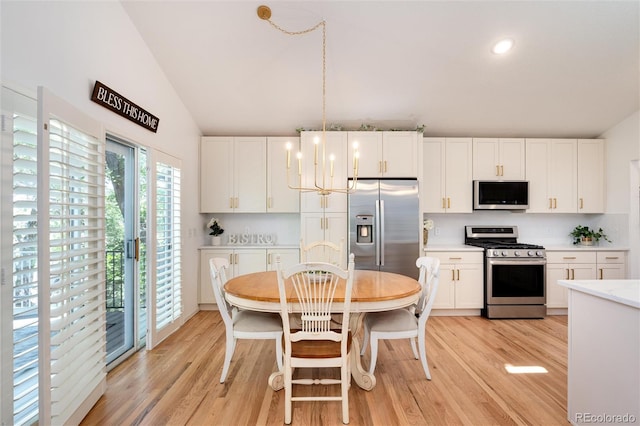 dining space featuring vaulted ceiling and light wood-type flooring