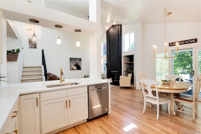 kitchen featuring dishwasher, decorative light fixtures, high vaulted ceiling, and sink