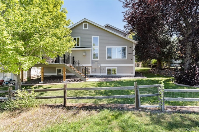 back of property featuring a wooden deck and a yard