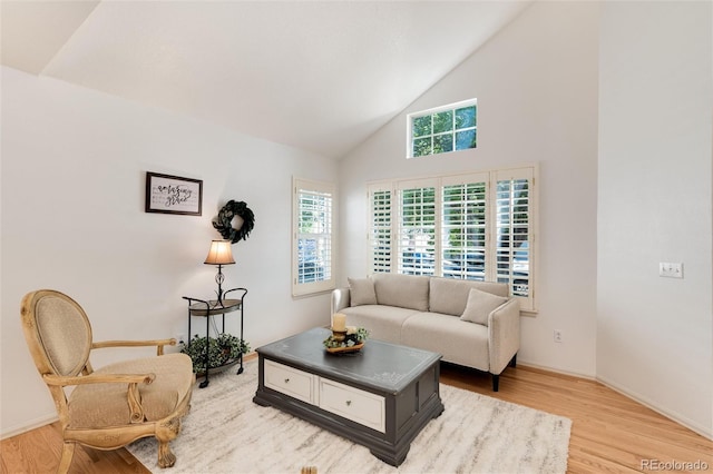 living room featuring high vaulted ceiling and light wood-type flooring