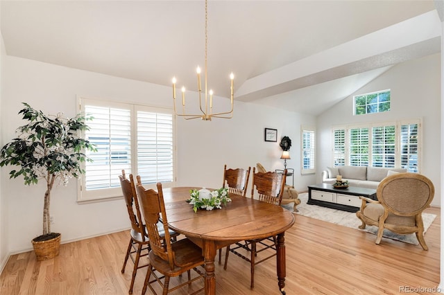 dining space with a notable chandelier, plenty of natural light, lofted ceiling, and light hardwood / wood-style flooring