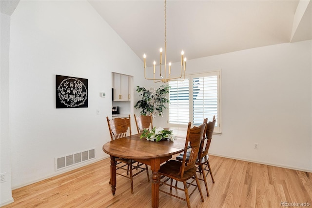 dining space featuring high vaulted ceiling, a notable chandelier, and light wood-type flooring