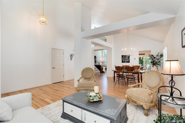 living room with a chandelier, high vaulted ceiling, and light hardwood / wood-style floors