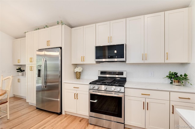 kitchen featuring stainless steel appliances, white cabinetry, light hardwood / wood-style floors, and light stone counters