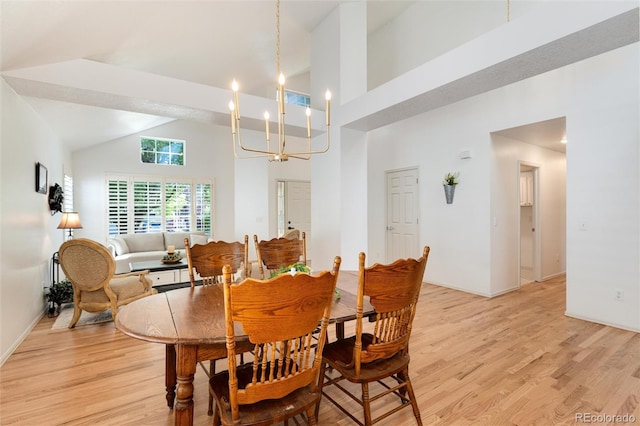 dining room featuring light wood-type flooring, high vaulted ceiling, and a notable chandelier