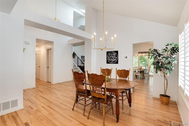 dining space featuring high vaulted ceiling, a chandelier, and light wood-type flooring