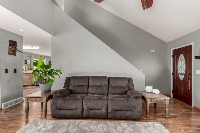 living room with ceiling fan, hardwood / wood-style floors, and vaulted ceiling