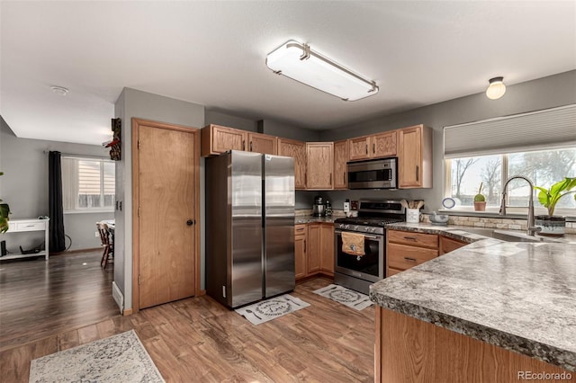 kitchen featuring appliances with stainless steel finishes, hardwood / wood-style flooring, and sink