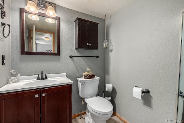 bathroom featuring vanity, toilet, and a textured ceiling