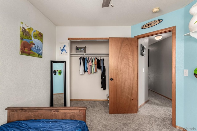 carpeted bedroom with ceiling fan and a closet