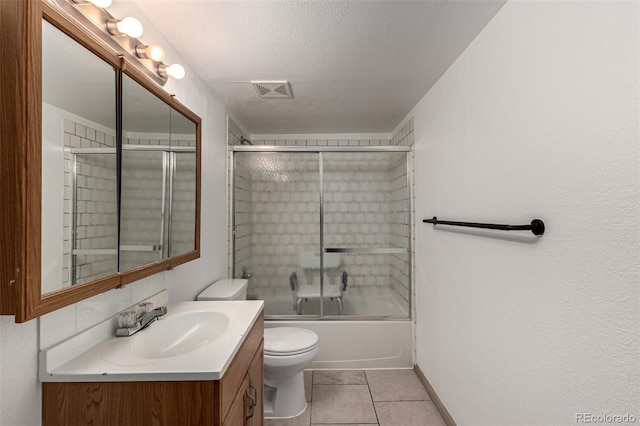 full bathroom featuring tile patterned floors, bath / shower combo with glass door, vanity, a textured ceiling, and toilet