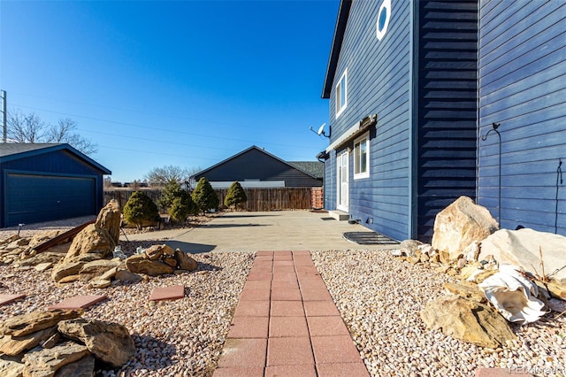 view of yard with a patio area, an outdoor structure, and a garage