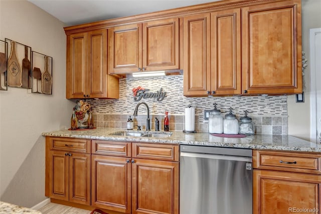 kitchen with decorative backsplash, dishwasher, light stone counters, and sink