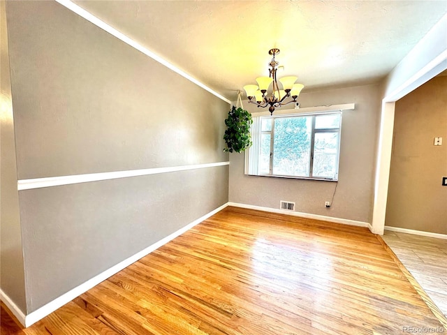 unfurnished dining area featuring hardwood / wood-style flooring and a chandelier