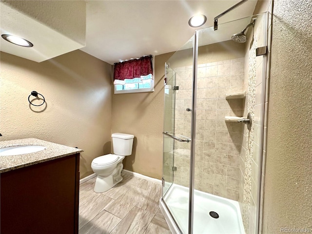 bathroom with vanity, toilet, and an enclosed shower