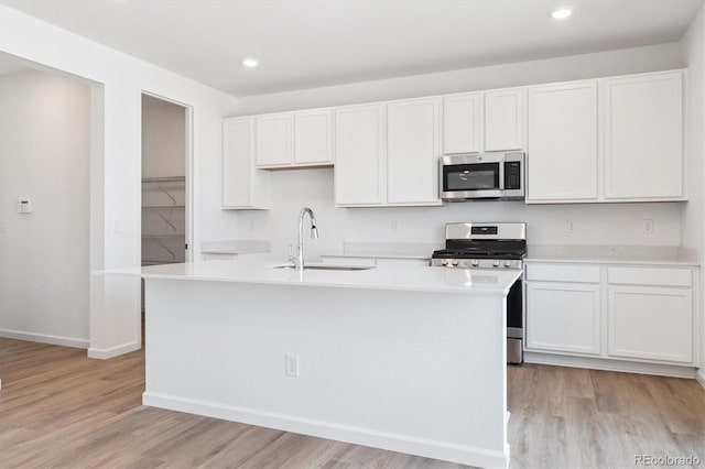 8339 Snake River St, Littleton, CO 80125 - kitchen with appliances with stainless steel finishes, light wood-type flooring, light countertops, white cabinets, and recessed lighting