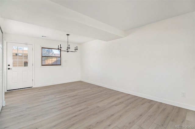 unfurnished dining area featuring a chandelier and light hardwood / wood-style flooring