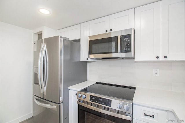 kitchen with white cabinetry, stainless steel appliances, and tasteful backsplash