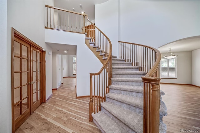 5416 S Hannibal Ct, Centennial, CO 80015 - stairs with french doors, wood finished floors, arched walkways, and a high ceiling