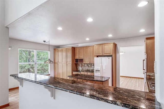 5416 S Hannibal Ct, Centennial, CO 80015 - kitchen featuring white refrigerator with ice dispenser, light wood-type flooring, backsplash, recessed lighting, and a center island