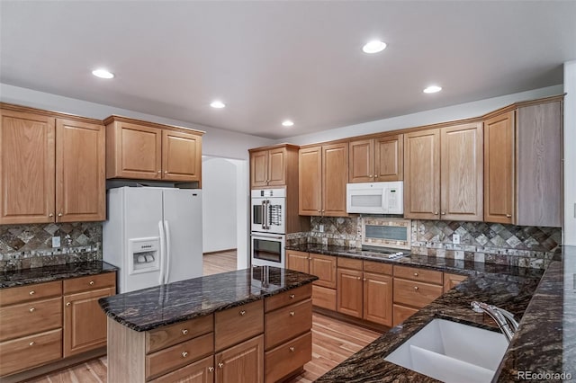 5416 S Hannibal Ct, Centennial, CO 80015 - kitchen with white appliances, decorative backsplash, light wood-style floors, dark stone counters, and recessed lighting