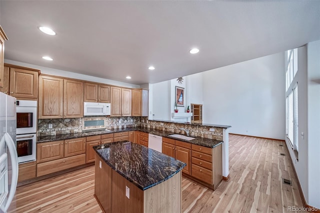 5416 S Hannibal Ct, Centennial, CO 80015 - kitchen with white appliances, a peninsula, tasteful backsplash, light wood finished floors, and recessed lighting