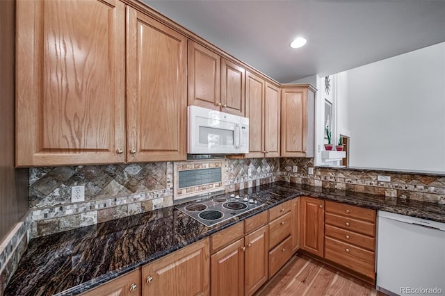5416 S Hannibal Ct, Centennial, CO 80015 - kitchen with white appliances, light wood-type flooring, dark stone counters, decorative backsplash, and recessed lighting
