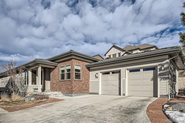 prairie-style home with an attached garage, concrete driveway, and brick siding