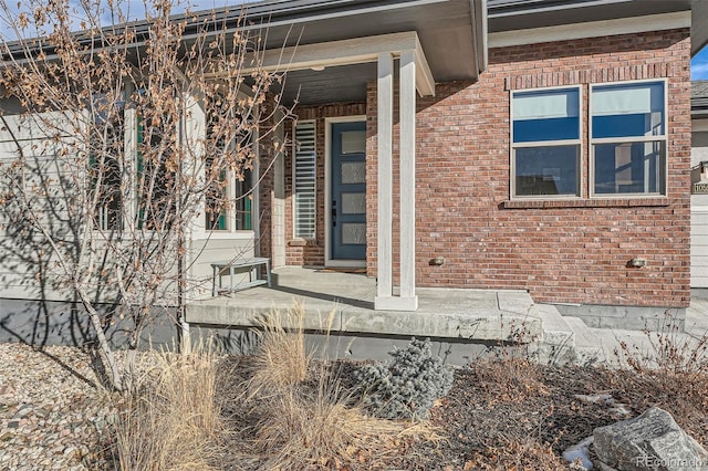 doorway to property with brick siding