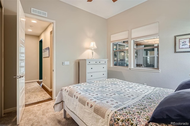 carpeted bedroom with baseboards, visible vents, and a ceiling fan