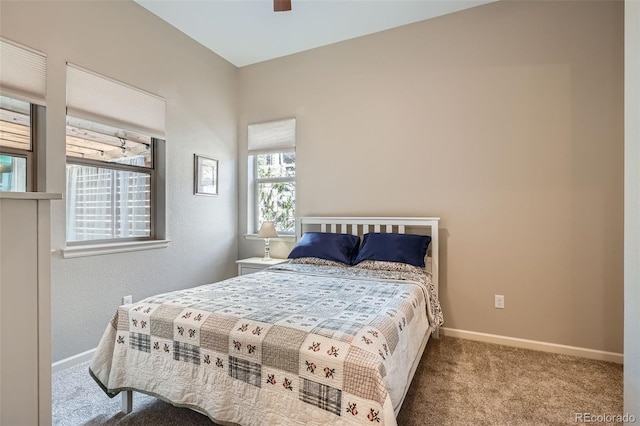 bedroom with a ceiling fan, light colored carpet, and baseboards