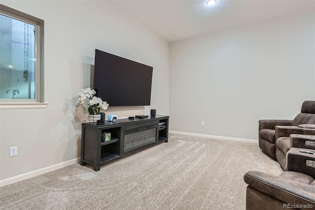 living area with baseboards and light colored carpet