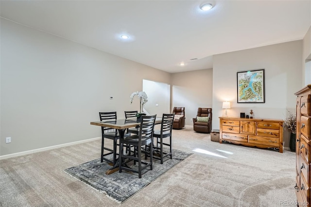 dining space with recessed lighting, light colored carpet, and baseboards