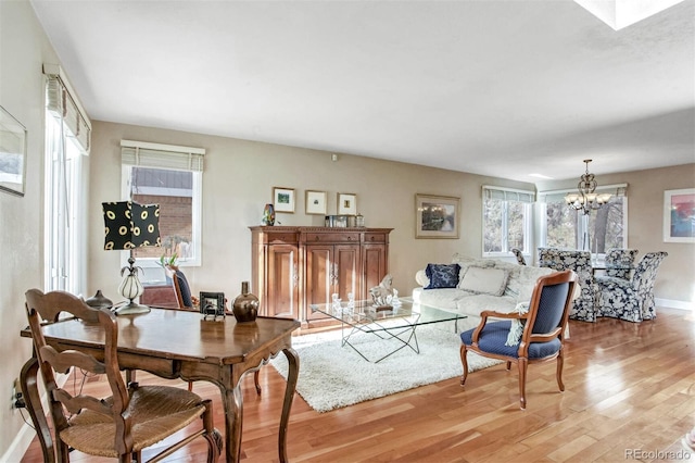 living room with a notable chandelier and light hardwood / wood-style floors