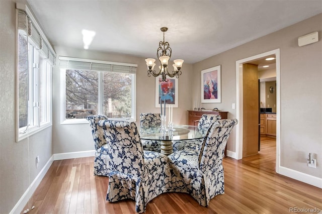 dining room with an inviting chandelier, plenty of natural light, and light hardwood / wood-style floors