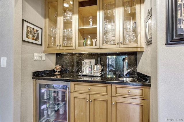 bar featuring wine cooler, sink, decorative backsplash, and dark stone counters