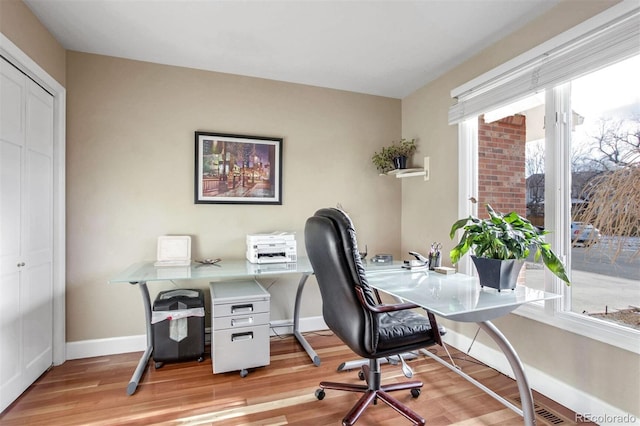 home office with light hardwood / wood-style flooring