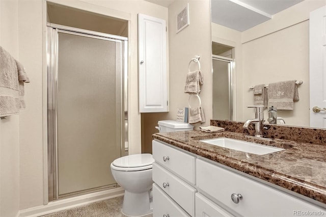 bathroom featuring vanity, an enclosed shower, and toilet