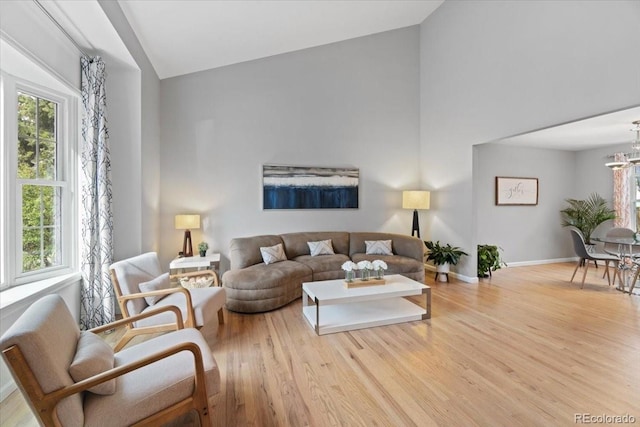 5310 S Flanders Way, Centennial, CO 80015 - living area featuring baseboards, an inviting chandelier, wood finished floors, and high vaulted ceiling