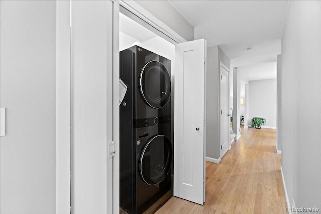 5310 S Flanders Way, Centennial, CO 80015 - laundry area with baseboards, stacked washer and clothes dryer, light wood-style flooring, and laundry area