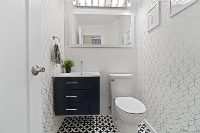 5310 S Flanders Way, Centennial, CO 80015 - half bathroom featuring toilet, tile walls, tile patterned flooring, and vanity
