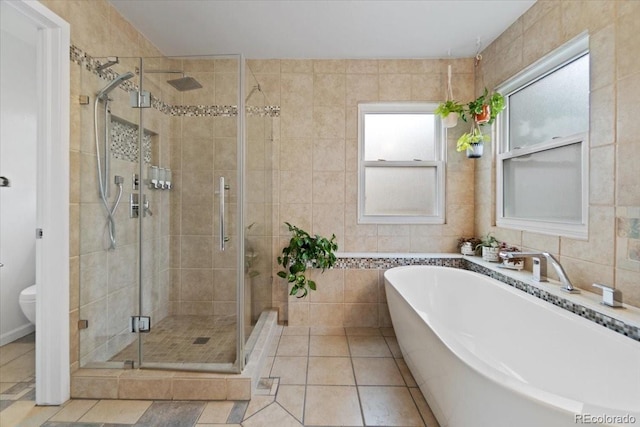 5310 S Flanders Way, Centennial, CO 80015 - full bathroom featuring a freestanding tub, tile walls, a stall shower, tile patterned floors, and toilet