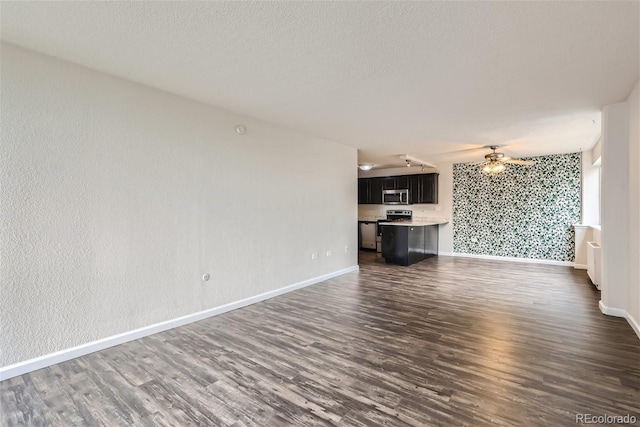 unfurnished living room featuring a textured ceiling, ceiling fan, and dark hardwood / wood-style floors