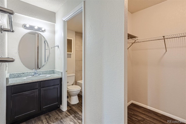 bathroom featuring toilet, wood-type flooring, and vanity