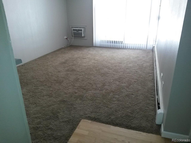 empty room with a wall mounted air conditioner and carpet