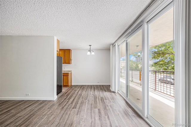 2225 Buchtel Blvd Unit 208, Denver, CO 80210 - unfurnished living room featuring wood finished floors, a chandelier, and a textured ceiling