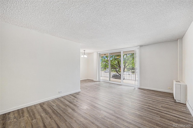 2225 Buchtel Blvd Unit 208, Denver, CO 80210 - spare room featuring wood finished floors, a textured ceiling, and a wall of windows
