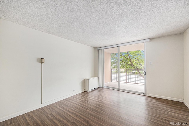 2225 Buchtel Blvd Unit 208, Denver, CO 80210 - unfurnished room featuring wood finished floors, radiator heating unit, a textured ceiling, and a wall of windows